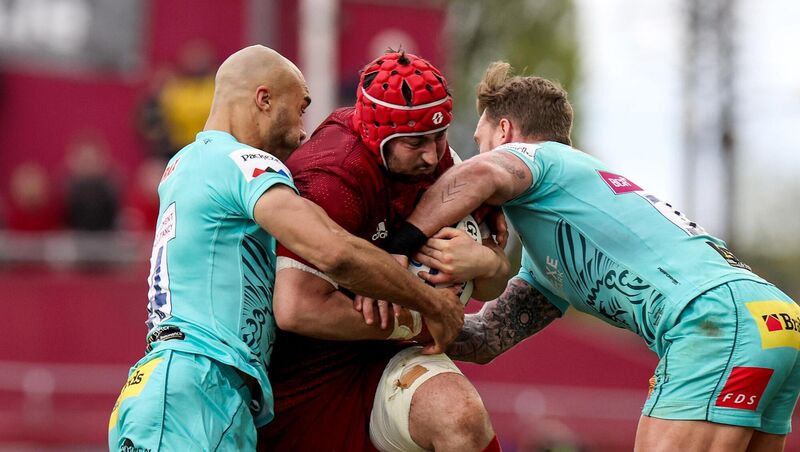 Munster's John Hodnett is tackled by Olly Woodburn and Stuart Hogg of Exeter Chiefs 