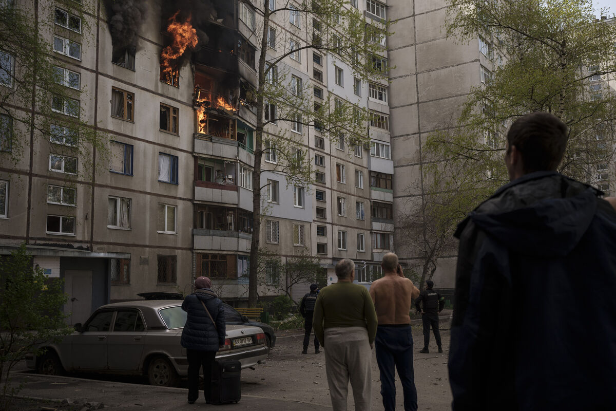 People watch as a residential building burns following a Russian bombardment in Kharkiv. Picture: AP Photo/Felipe Dana