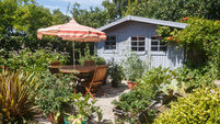 W6T1AE Shed with terrace and wooden garden furniture during summer