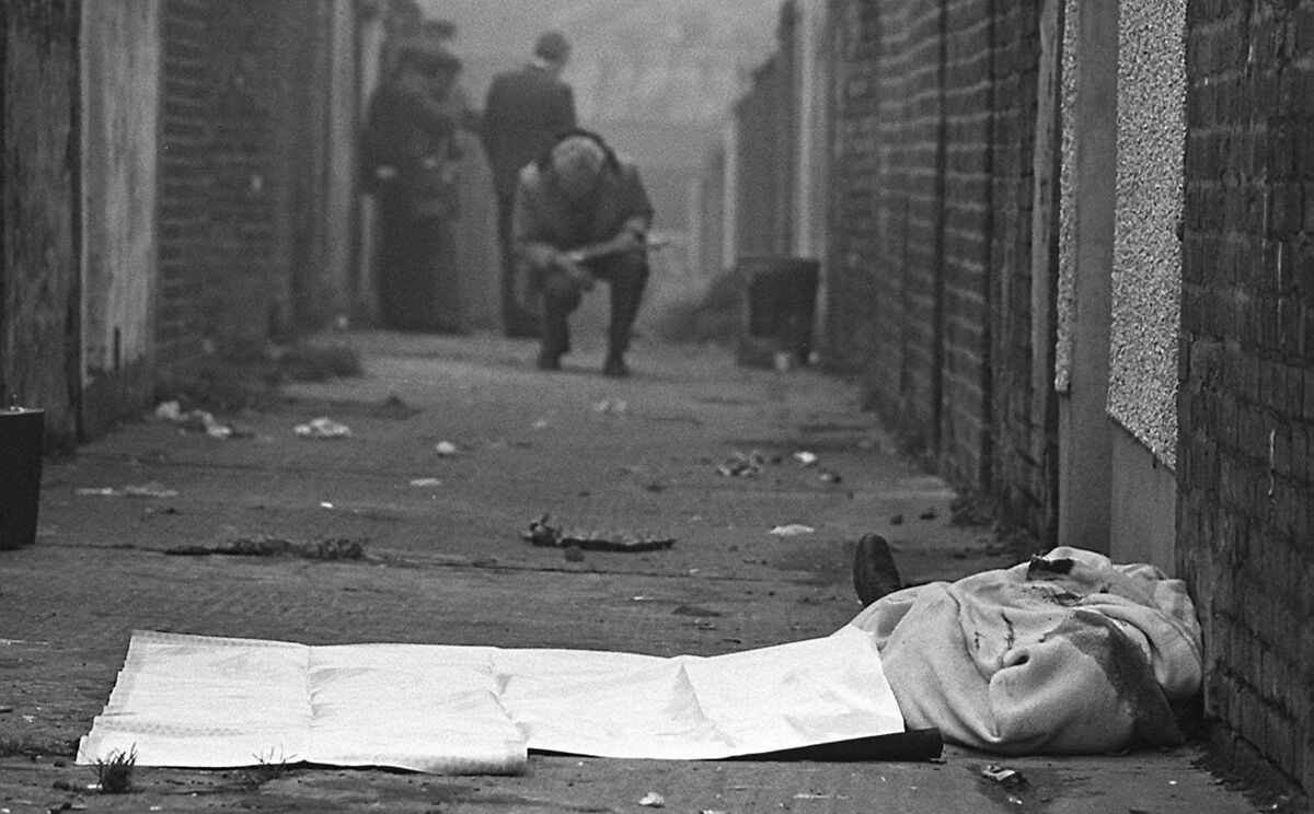 The body of Catholic man Joseph Donegan lies in an entry off the Shankill Road in West Belfast, after being murdered by members of the Shankill Butchers in 1982. Pic: Pacemaker Belfast