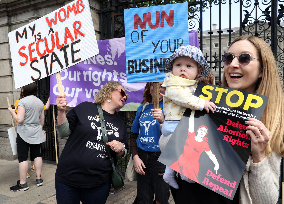 Six-month-old Donnacha Moon-Hannon and Aileen Moon (right) take part in a protest outside Leinster House in Dublin against the ownership and governance structure of a new National Maternity Hospital.