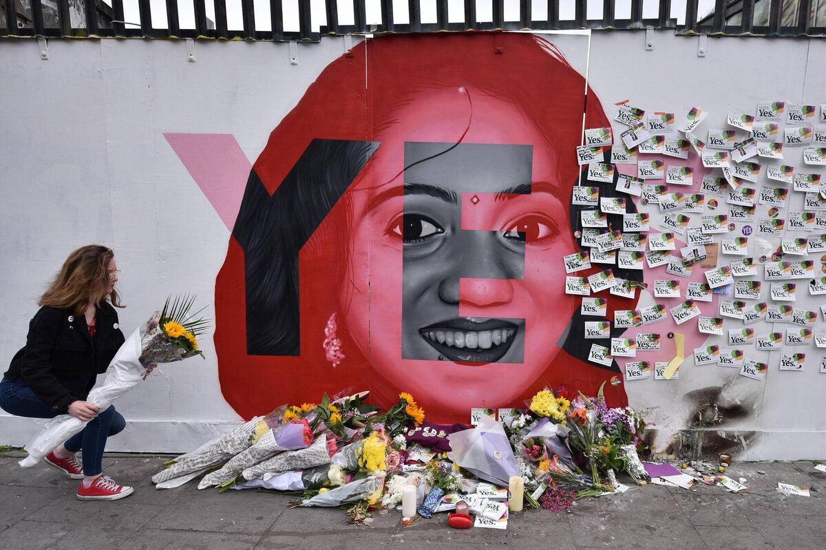 A young woman leaves flowers at the Savita Halappanavar mural as the results in the  referendum on the 8th Amendment on the country's abortion laws takes place at Dublin Castle on May 26, 2018. Picture: Charles McQuillan/Getty Images
