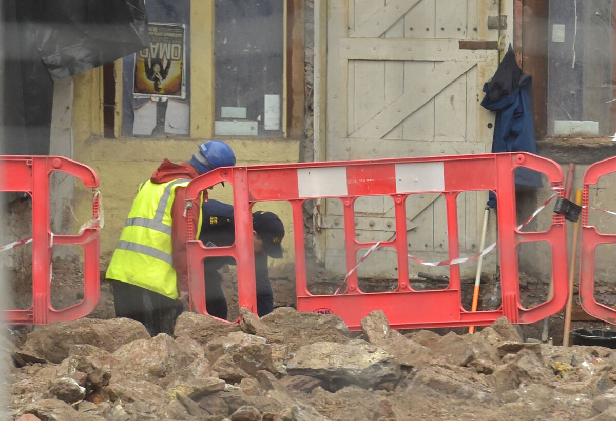  A Garda with a workman at the excavation site. Picture: Dan Linehan