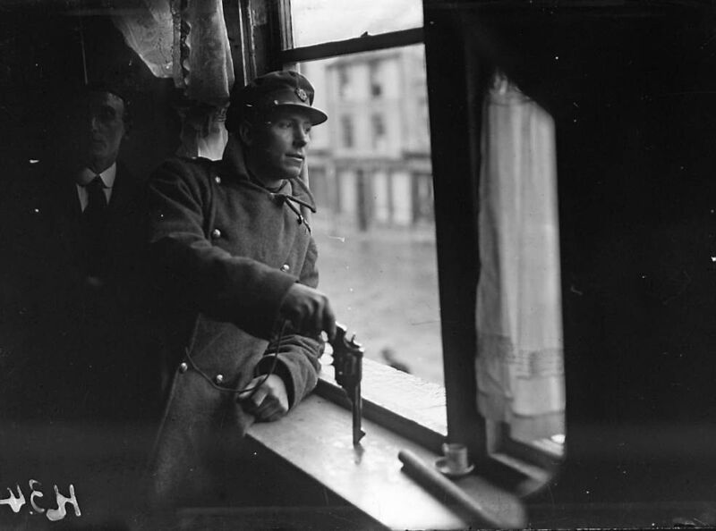 A member of the Free State National Army stands guard at a window, armed with a revolver, in 1922.  	Picture: Independent News And Media/Getty
                    