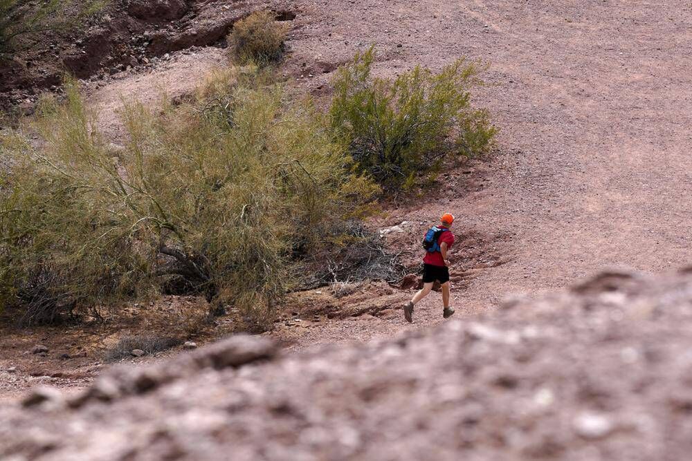 A jogger runs along a desert path in Papago Park, Phoenix. Picture: AP/ Ross D Franklin