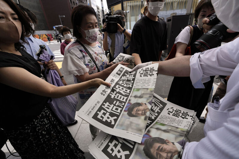 An employee distributes extra editions of the Yomiuri Shimbun newspaper reporting that Japan's former Prime Minister Shinzo Abe was shot. Picture: AP Photo/Eugene Hoshiko
