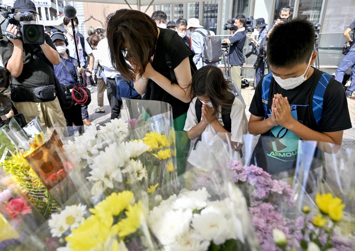 People offer prayers at a makeshift memorial near the scene where the former Prime Minister Shinzo Abe was fatally shot while delivering his speech to support the Liberal Democratic Party's candidate during an election campaign in Nara. Picture: Kyodo News via AP People offer prayers at a makeshift memorial near the scene where the former Prime Minister Shinzo Abe was fatally shot while delivering his speech to support the Liberal Democratic Party's candidate during an election campaign in Nara. Picture: Kyodo News via AP