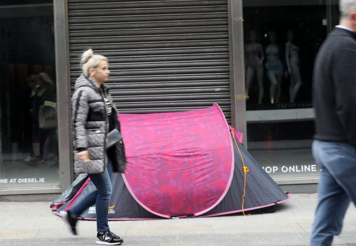 People sleeping rough in a tent on Grafton Street in Dublin as shoppers walk past. Picture: Leah Farrell/RollingNews.ie