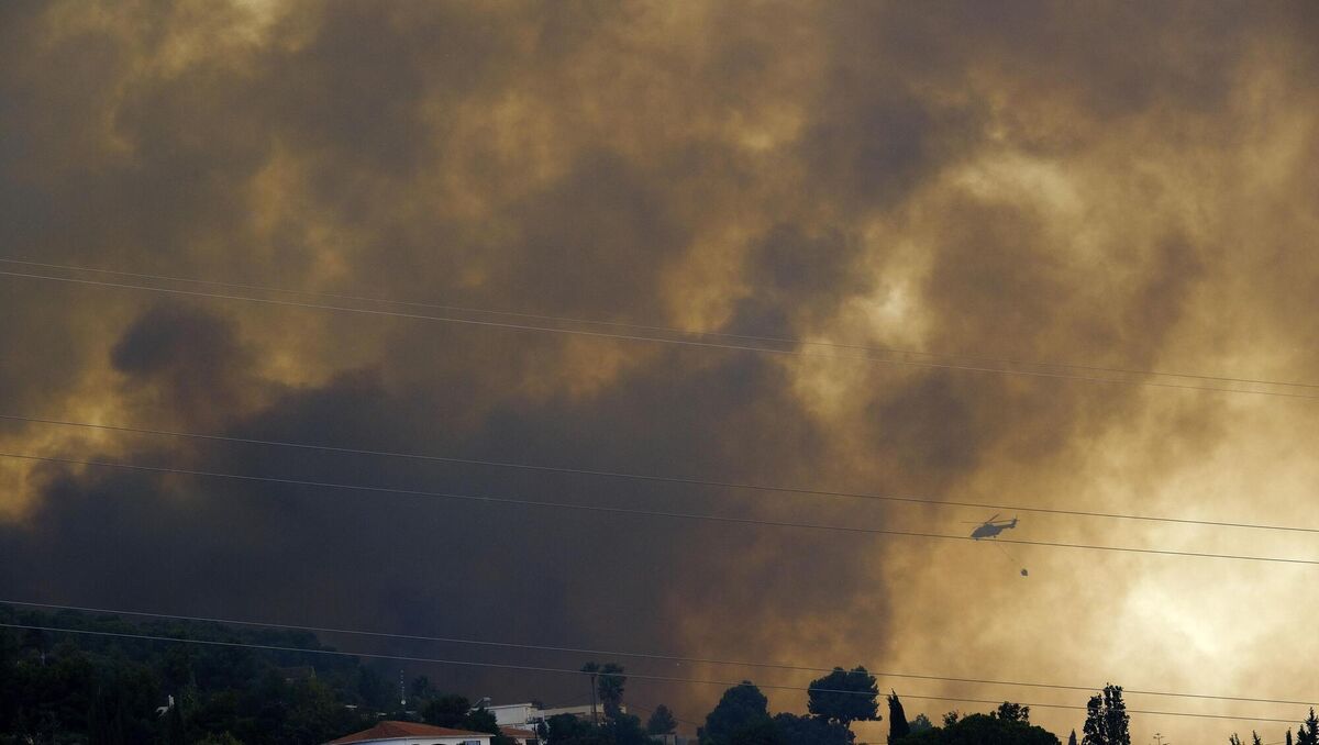 A helicopter launches water as a wildfire advances near a residential area, in Alhaurin de la Torre, Malaga, Spain. Picture: AP Photo/Gregorio Marrero 