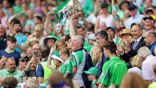 <p>Limerick manager John Kiely lifts the Liam MacCarthy Cup</p>