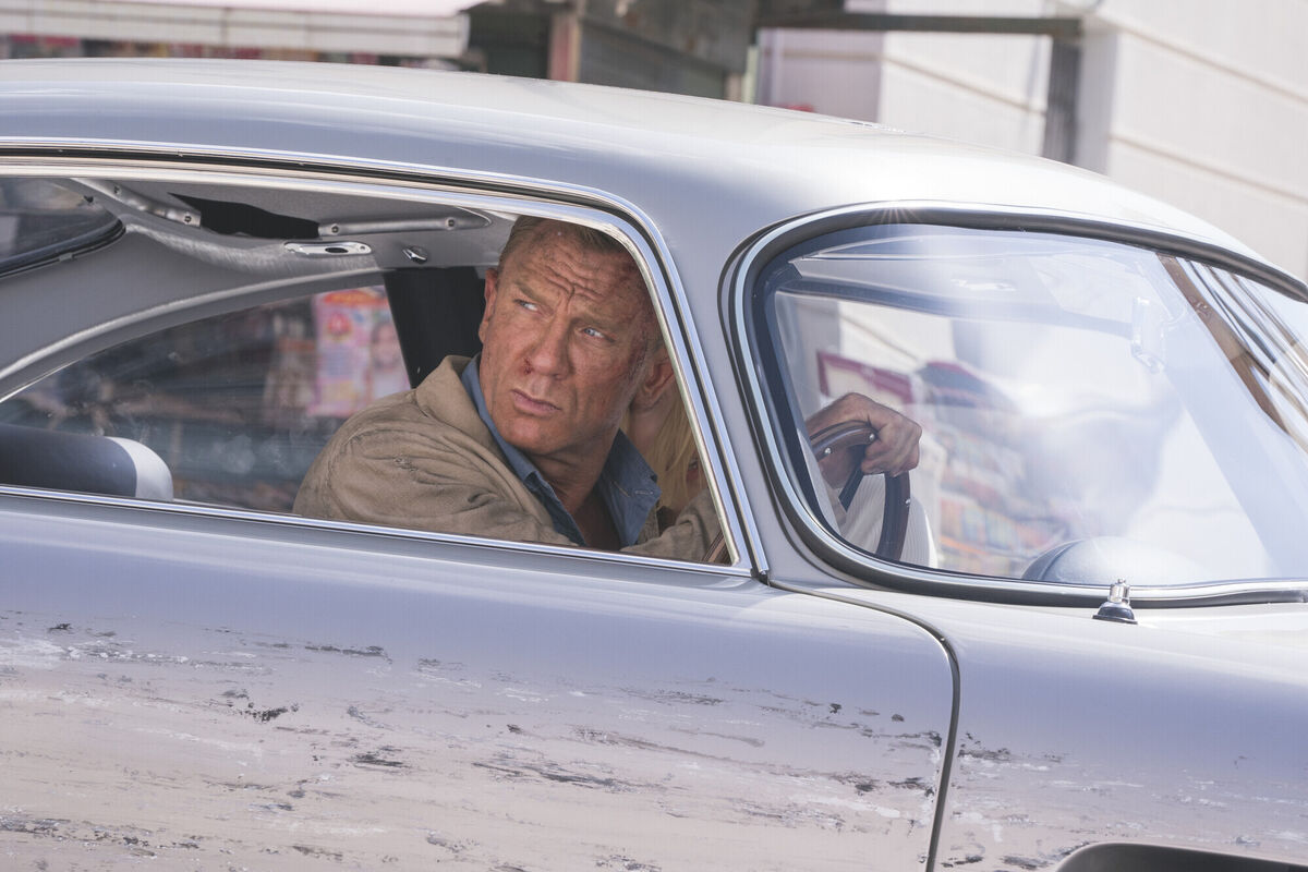 Daniel Craig driving an Aston Martin DB5 stunt car. © 2021 Danjaq, LLC and Metro-Goldwyn-Mayer Studios Inc 