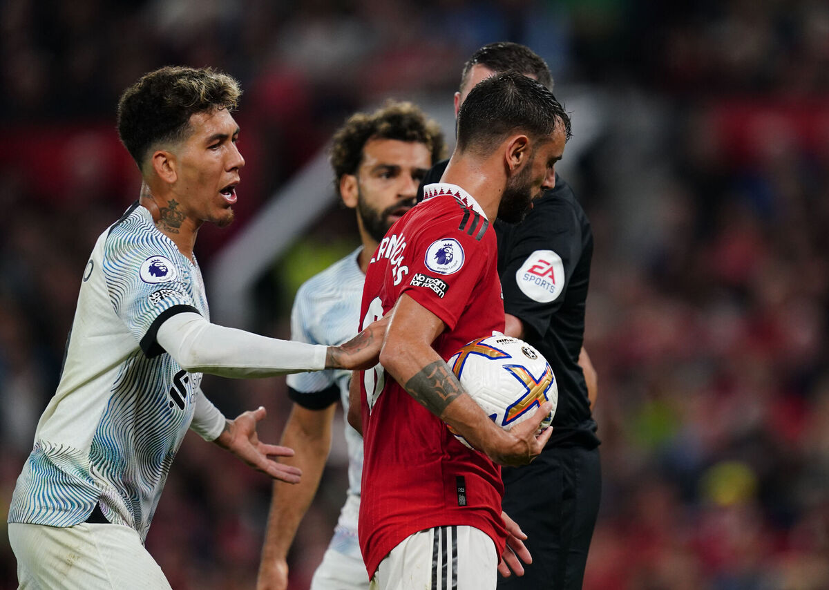 Manchester United's Bruno Fernandes keeps the ball away from Liverpool's Roberto Firmino. 