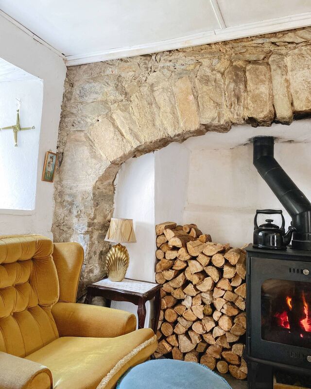 After: Maggie knocked down the plaster until she found the old stone arch behind it, adding a new stove. 