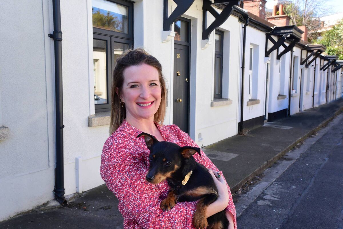Jennifer Sheahan and Perry outside her artisan cottage. The exterior is painted with a water-based paint which won't yellow over time. Pictures: Moya Nolan Jennifer Sheahan and Perry outside her artisan cottage. The exterior is painted with a water-based paint which won't yellow over time. Pictures: Moya Nolan