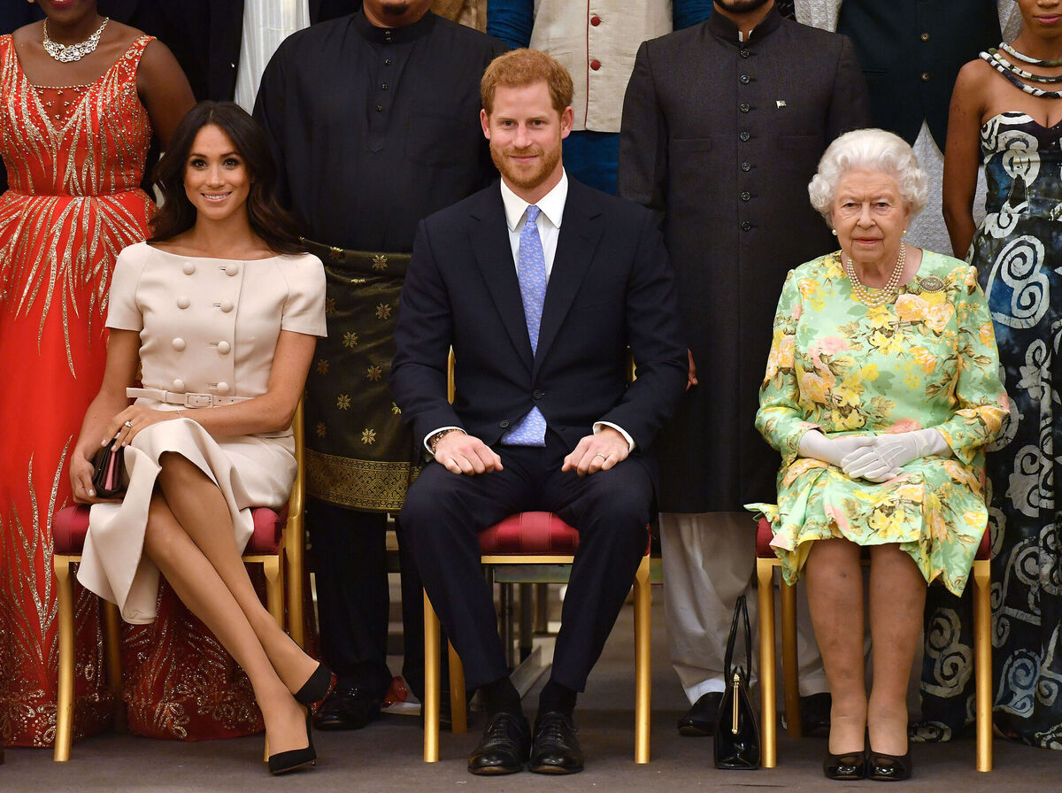 Queen Elizabeth with Harry and Meghan during a group photo at the Queen's Young Leaders Awards Ceremony at Buckingham Palace, London.