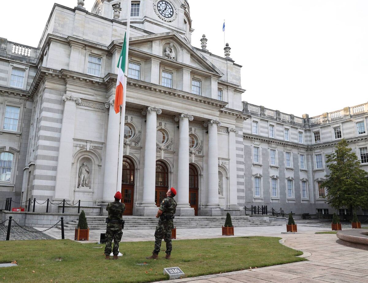 Defence Forces military police lower the Irish flag to half-mast outside government buildings in Dublin after the announcement of the death of Britain's Queen Elizabeth. Picture: Government Information Service