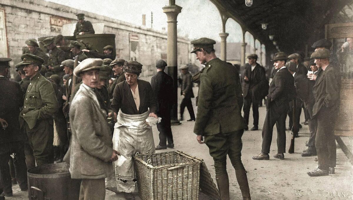 Following the taking of Cork, troops gather at Albert Quay Station, with the Peerless armoured car in the background.