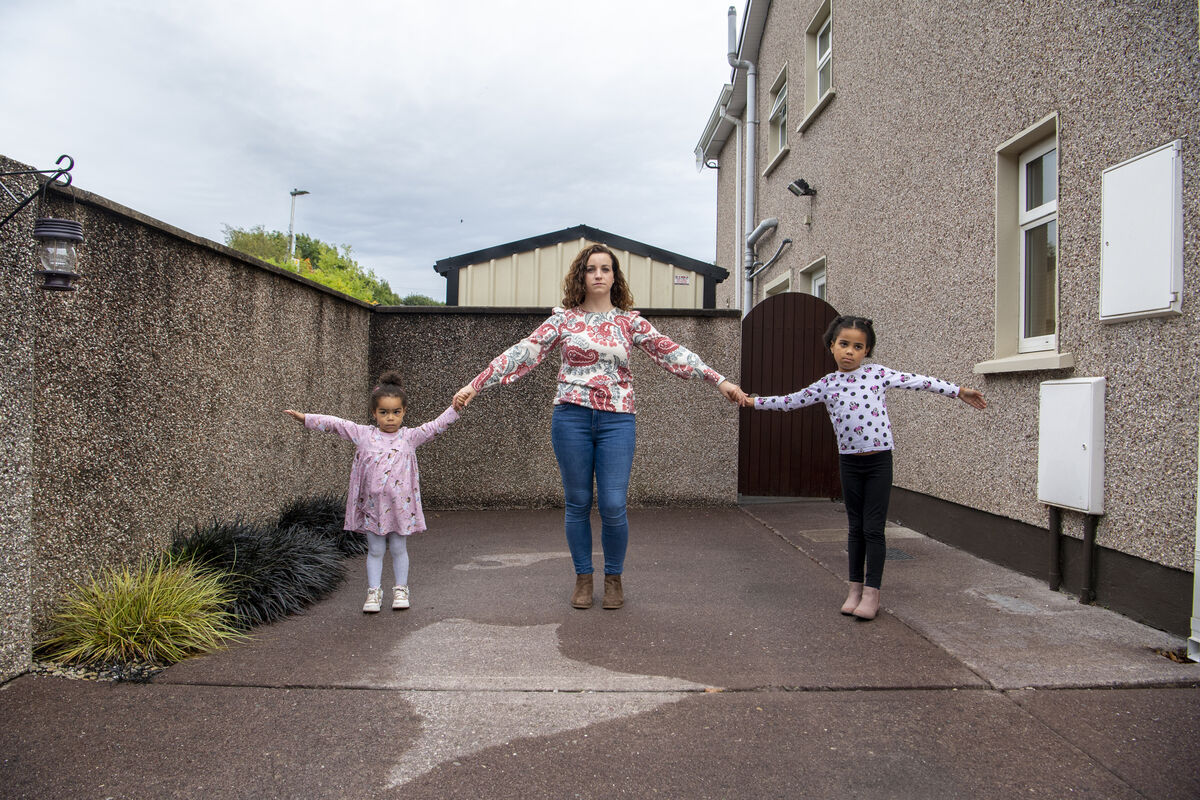 Sarah Adeleke and her children Rosa and Elise at the front drive of their house at Curragh Woods, Frankfield, Cork, and the boundary wall which will be knocked under the BusConnects plan to make room for bus and bike lanes on  Ballycurreen/Airport Rd. Picture: Dan Linehan