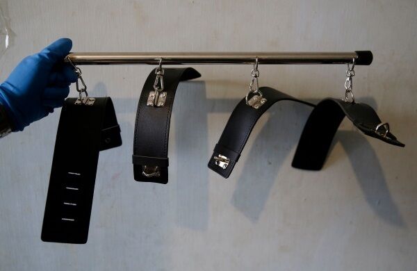 A member of the National Bureau of Investigation anti-human trafficking division displays bondage cuffs used for sexual acts. A member of the National Bureau of Investigation anti-human trafficking division displays bondage cuffs used for sexual acts.