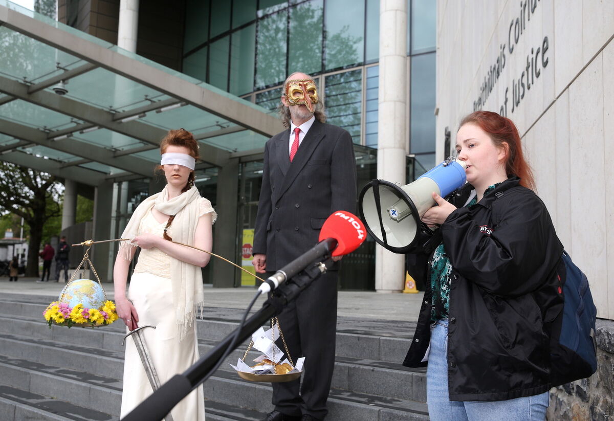 Extinction Rebellion activist Ceara Carney dressed blindfolded in a gown as Lady Justice with Louis Heath in a suit to represent the state and activist Orla Murphy on the steps of the Criminal Court of Justice in Dublin in a theatrical protest to show the injustice of climate inaction when Ms Murphy appeared in court for a criminal damage case. Picture: Gareth Chaney/ Collins Photos
