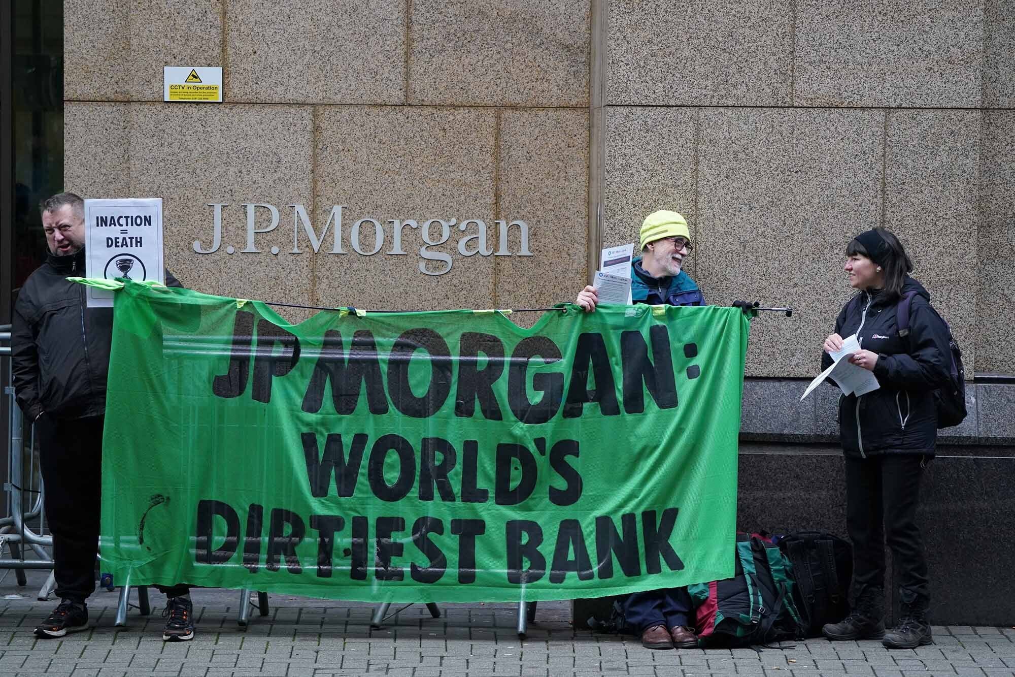 Activists from Extinction Rebellion locked to an oil barrel as they protest outside the offices of JP Morgan in Glasgow, a reprise of a protest they staged at last year's Cop26 summit in the city.
