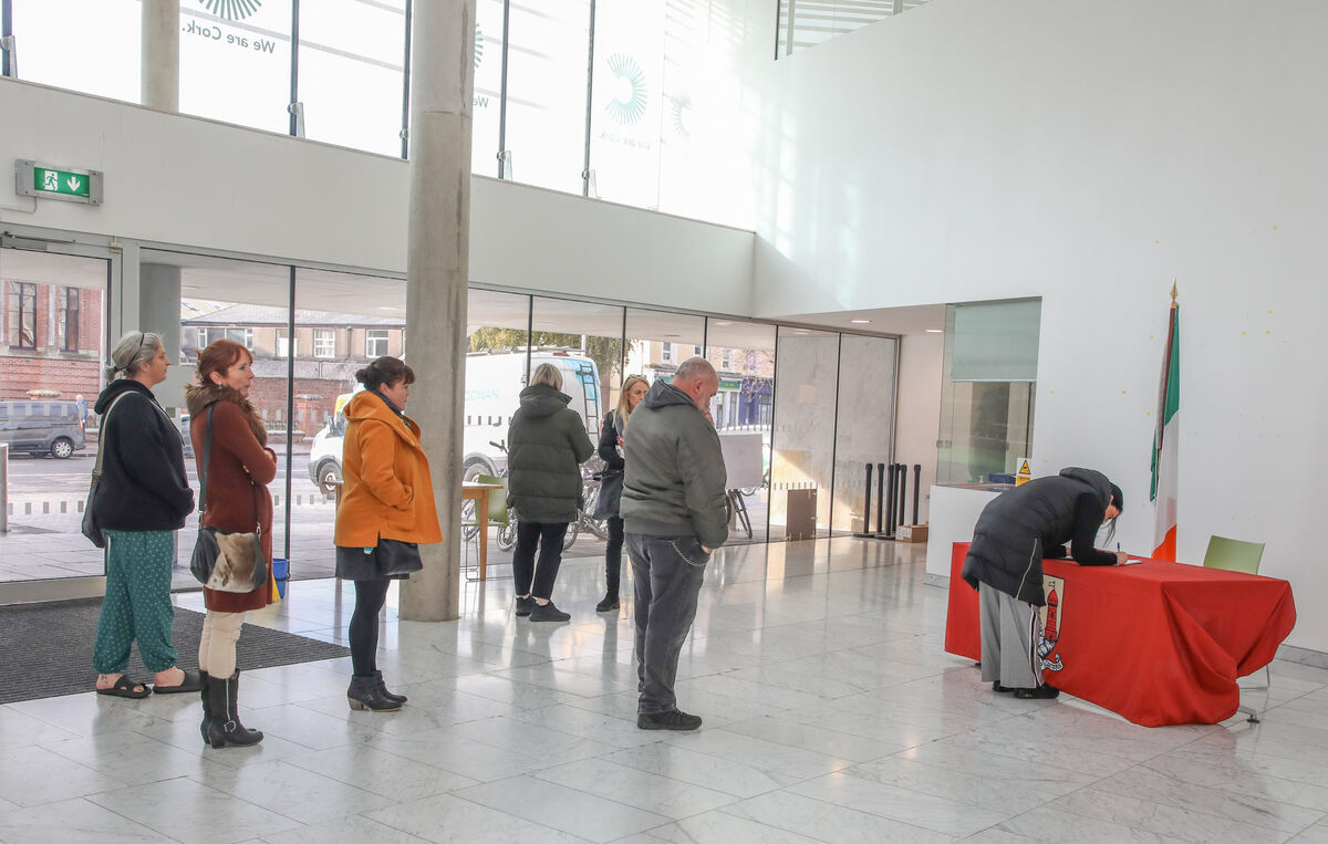 People queue to sign of the book of condolences at Cork City Hall on Tuesday. Picture: David Creedon