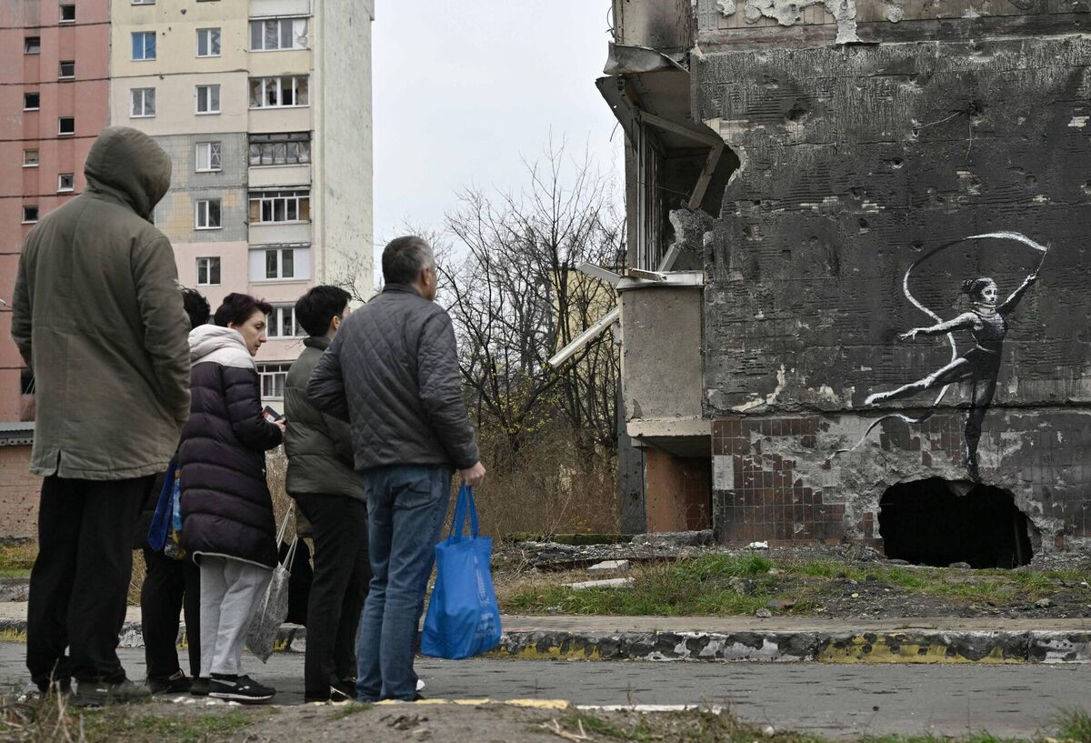 Local residents look at a Banksy-style graffiti on the wall of a destroyed residential building, but its origin remains unconfirmed by the artist, in Irpin, near Kyiv on November 12. Picture: Genya Savilov/AFP via Getty Images