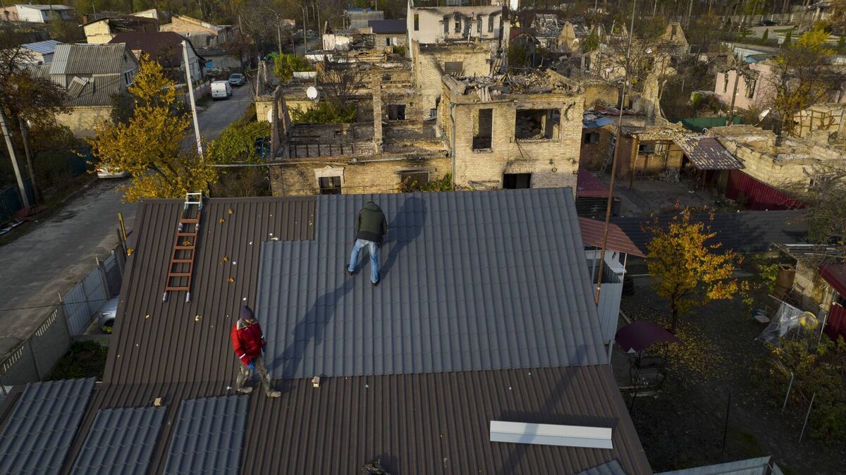 
                        Construction workers rebuild a roof on a home that was shelled in a destroyed neighborhood in Irpin, Ukraine.
                    