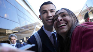 <p>TAKE OFF: Portugal's Cristiano Ronaldo poses for a photo with Giuliana, a fan from Brazil, as he arrives with the Portuguese team at Lisbon airport to depart for the World Cup in Qata on Friday. Picture: AP Photo/Armando Franca</p>
