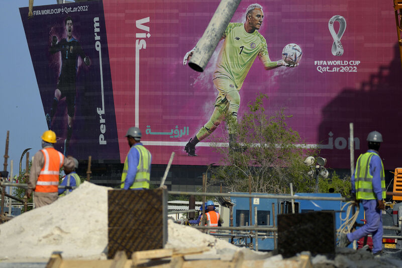 A billboard depicting Costa Rica's goalkeeper Keylor Navas and Belgium's goalkeeper Thibaut Courtois is displayed on the background as workers work on a street in Doha, Qatar, Saturday, November 12, 2022. Picture: Hassan Ammar/AP A billboard depicting Costa Rica's goalkeeper Keylor Navas and Belgium's goalkeeper Thibaut Courtois is displayed on the background as workers work on a street in Doha, Qatar, Saturday, November 12, 2022. Picture: Hassan Ammar/AP