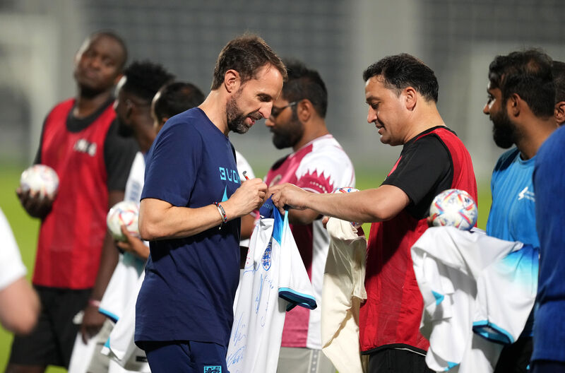 England manager Gareth Southgate signs shirts for the Workers' Welfare 'Team 360' players during a Community Engagement event at the Al Wakrah Sports Club Stadium in Al Wakrah, Qatar. Picture: England manager Gareth Southgate signs shirts for the Workers' Welfare 'Team 360' players during a Community Engagement event at the Al Wakrah Sports Club Stadium in Al Wakrah, Qatar. Picture: