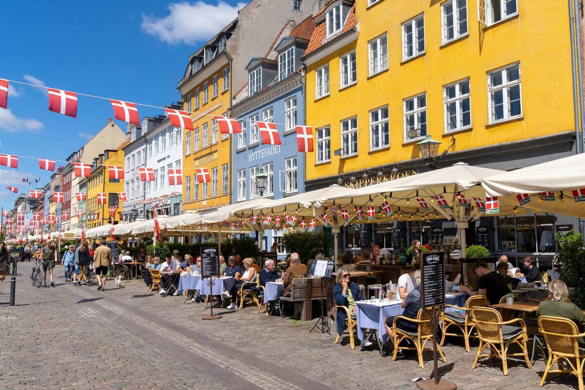 People enjoy a summer day in the busy Nyhavn quarter on the waterfront in Copenhagen.