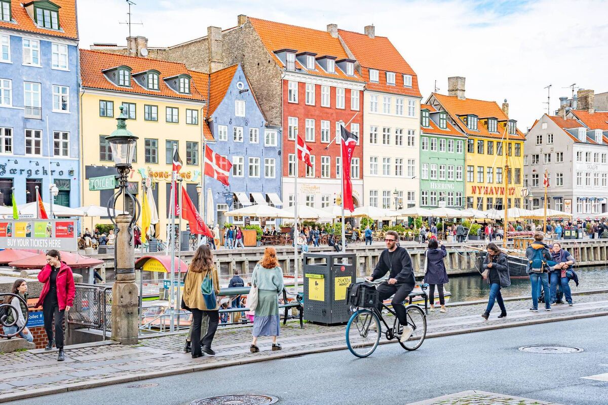 A cyclist, pedestrians and tourists in Christianshavn neighborhood in Copenhagen.