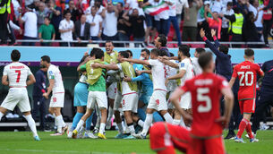 <p>CONTRASTING EMOTIONS: Iran's Roozbeh Cheshmi celebrates scoring their side's first goal. Picture: Martin Rickett/PA Wire.</p>