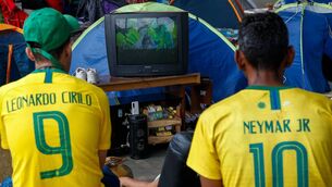 <p>Homeless people watch on TV a live broadcast of the Qatar 2022 World Cup Group G football match between Brazil and Switzerland, in Sao Paulo. Picture: MIGUEL SCHINCARIOL/AFP via Getty Images</p>