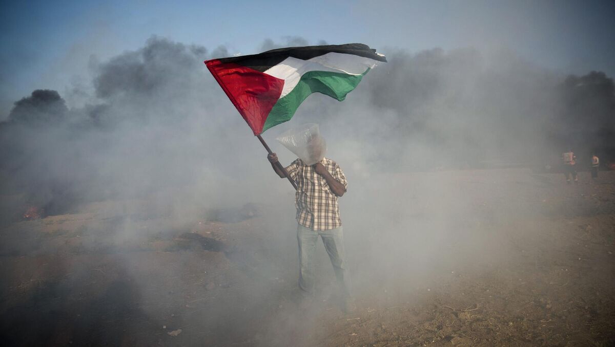 A Palestinian protester wears a plastic bag on his head as a protection from teargas.