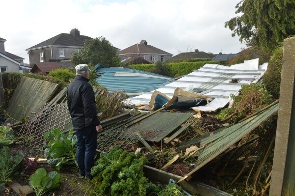 OCTOBER: Brendan Coleman looking at a section of the roof off the Douglas Community School gym which was blown through his garden in the height of Storm Ophelia. Picture: Dan Linehan