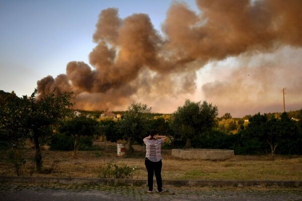 JULY: A distressed woman looks on at the column of smoke during a wildfire in Macao, central Portugal, on July 26. Picture: Patricia De Melo Moreira/AFP/Getty