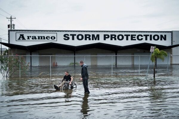 Brad Matheney offers help to a man in a wheelchair in a flooded street while Hurricane Harvey passes through Texas in August.