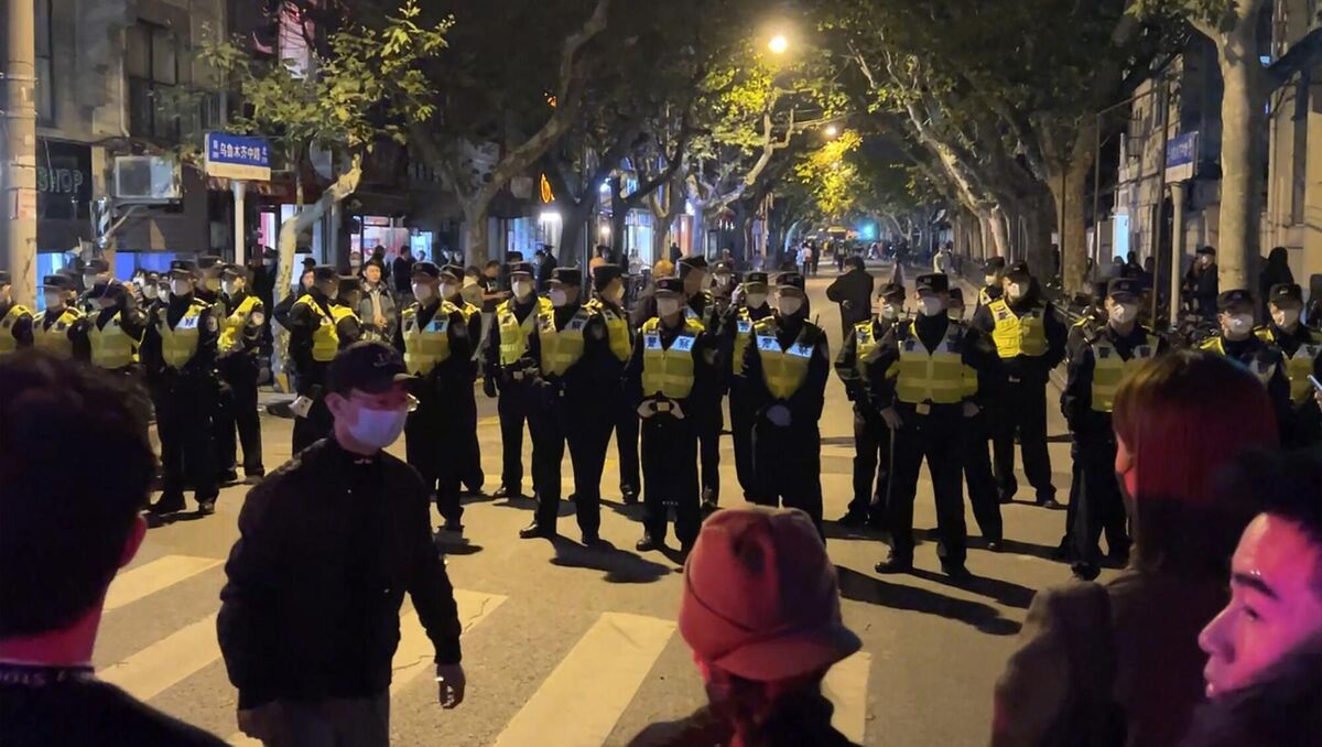 Chinese police officers block off access to a site where protesters had gathered in Shanghai on Sunday, November 27. Picture: AP Chinese police officers block off access to a site where protesters had gathered in Shanghai on Sunday, November 27. Picture: AP