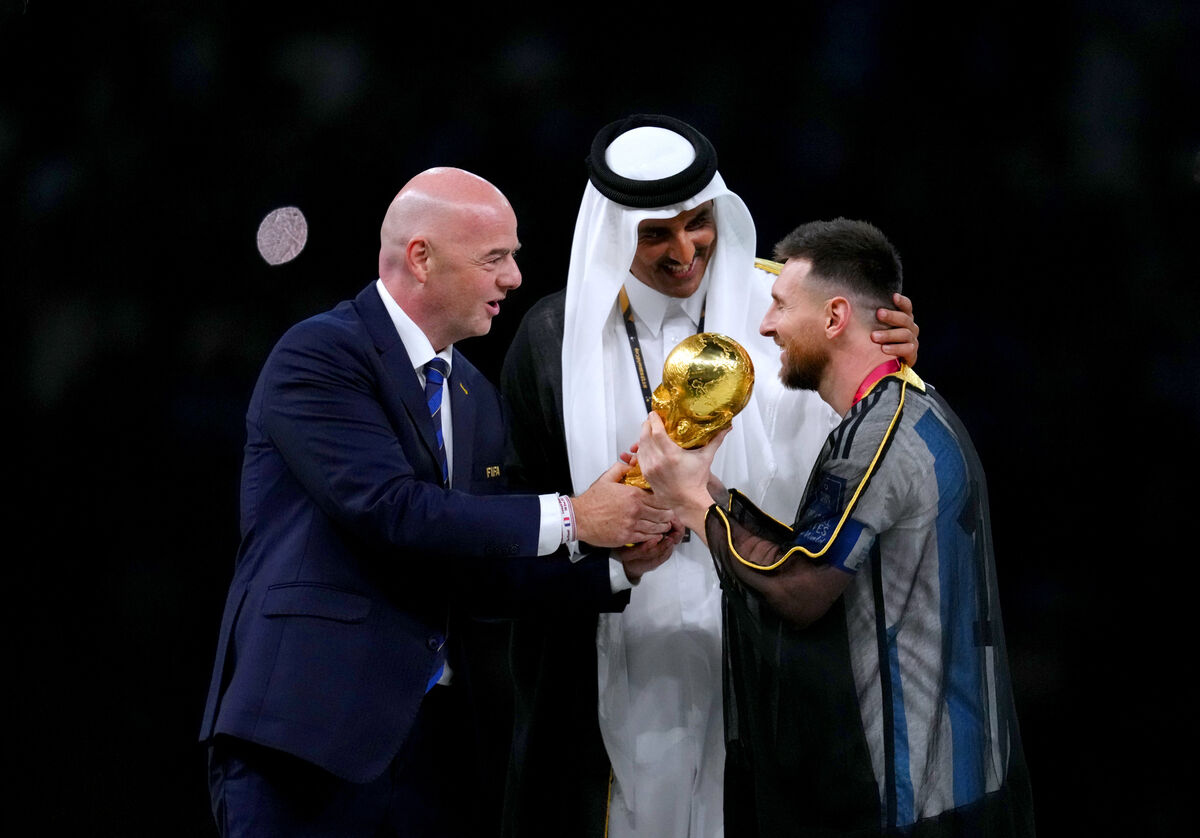 FIFA president Gianni Infantino (left) and The Emir of Qatar, Sheikh Tamim bin Hamad Al Thani present Argentina captain Lionel Messi with the FIFA World Cup trophy.