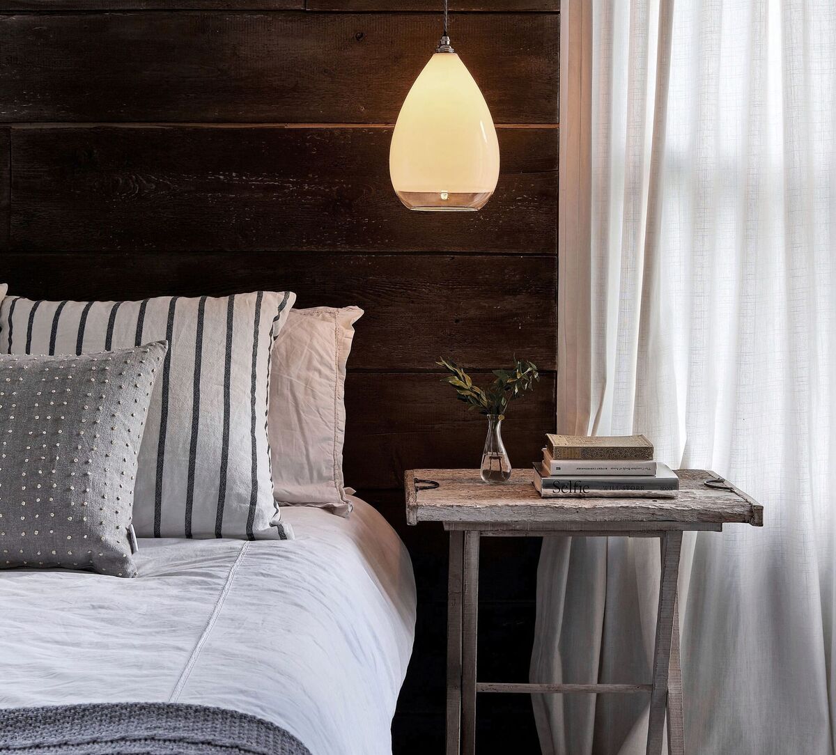 Linen sheets and a deep brown wood panelling in horizontal rustic boards. Brown here strikes an organic note in the right honest company. Wellington Pendant by Fritz Fryer, €289, fritzfryer.co.uk.