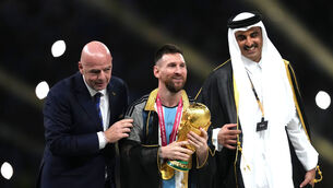 <p>SHARING THE LIMELIGHT: Argentina's Lionel Messi (centre) with the World Cup trophy as FIFA President Gianni Infantino (left) and Emir of Qatar, Sheikh Tamim bin Hamad Al Thani look on. Pic: Martin Rickett/PA Wire</p>
