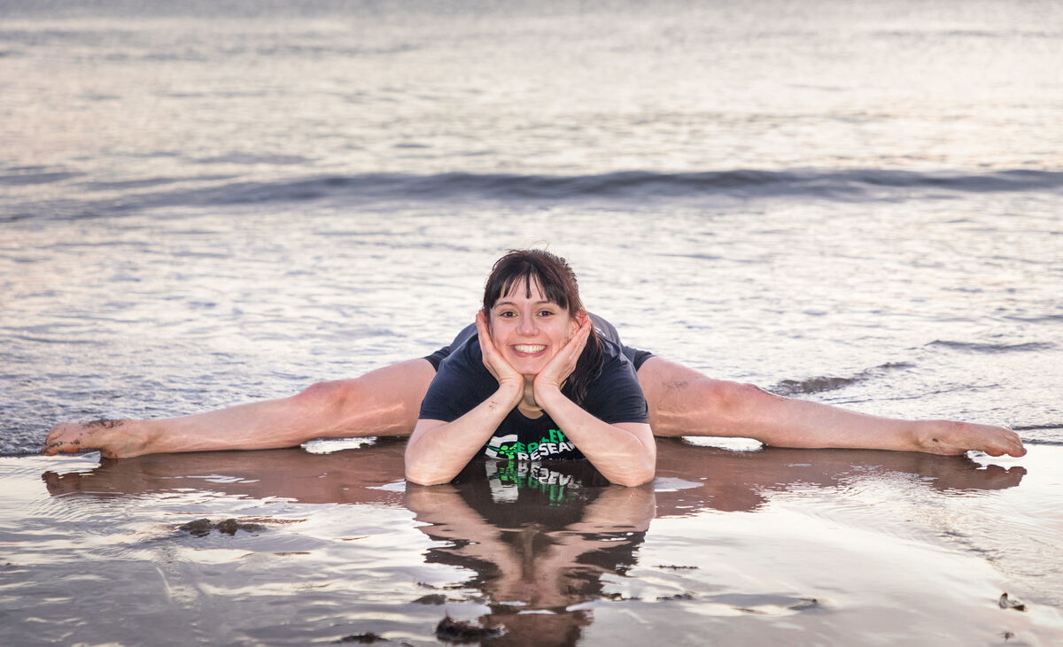 Sarah Hosford from Passage doing some stretches after her Christmas morning at Myrtleville Beach, 2020. Picture: David Creedon / Anzenberger