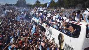 Football fans welcome home the Argentine soccer team after it won the World Cup (Victor Caivano/AP/PA)