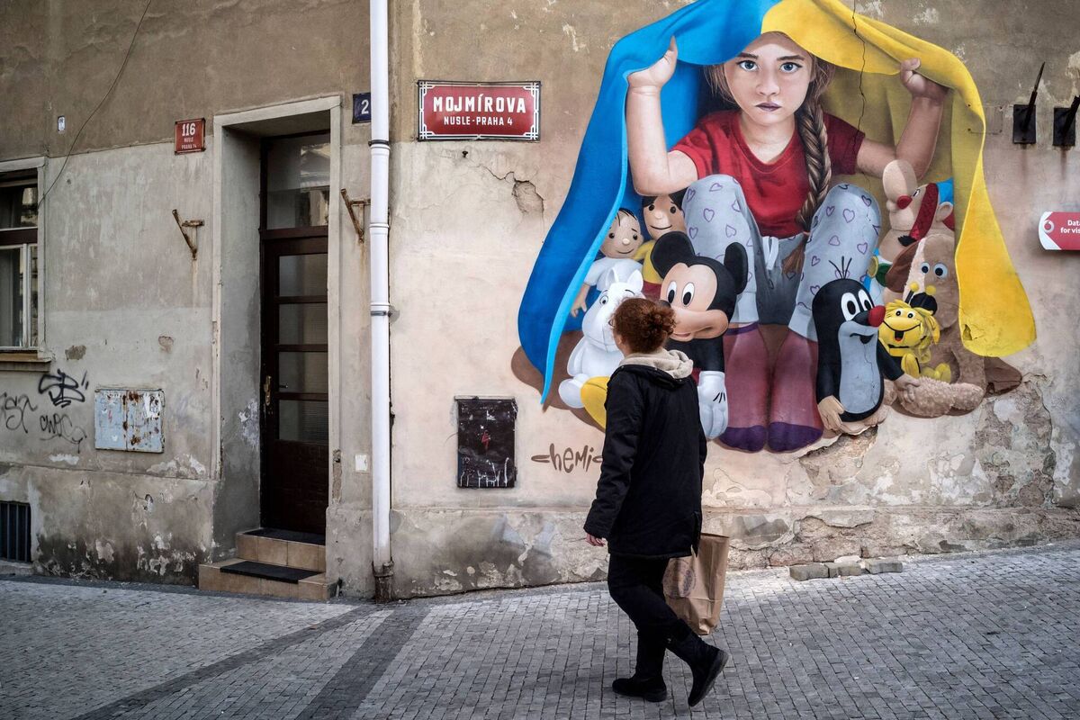 A mural in Prague, by artist ChemiS, showing a child sheltering with a Ukrainian flag. Picture: Michal Cizek / AFP 