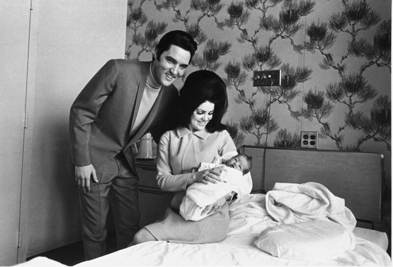 Lisa Marie Presley poses for her first picture, in the lap of her mother, Priscilla, on Feb. 5, 1968, with her father, Elvis Presley. Lisa Marie Presley — the only child of Elvis Presley and a singer herself — was hospitalized Thursday, Jan. 12, 2023, her mother said in a statement. (AP Photo/Perry Aycock, File)