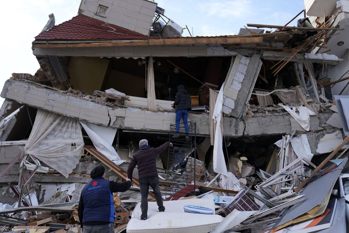 A man stands inside a destroyed building as others react. Picture: AP Photo/Hussein Malla A man stands inside a destroyed building as others react. Picture: AP Photo/Hussein Malla