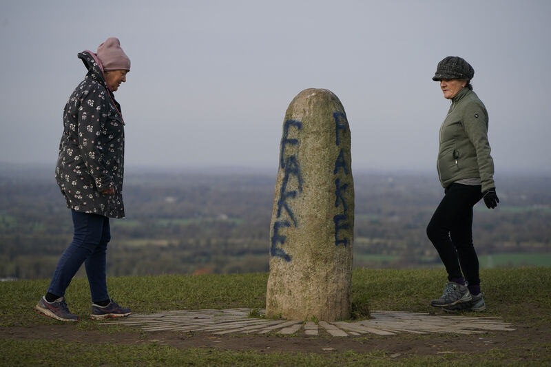 Members of the public look at graffiti on the Lia Fail standing stone, which is also known as the Stone of Destiny, on the Hill of Tara near Skryne in County Meath. 