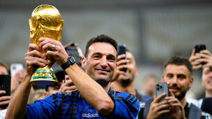 <p>'BEST'?: Argentina manager Lionel Scaloni celebrates with the FIFA World Cup trophy. Pic: PA</p>